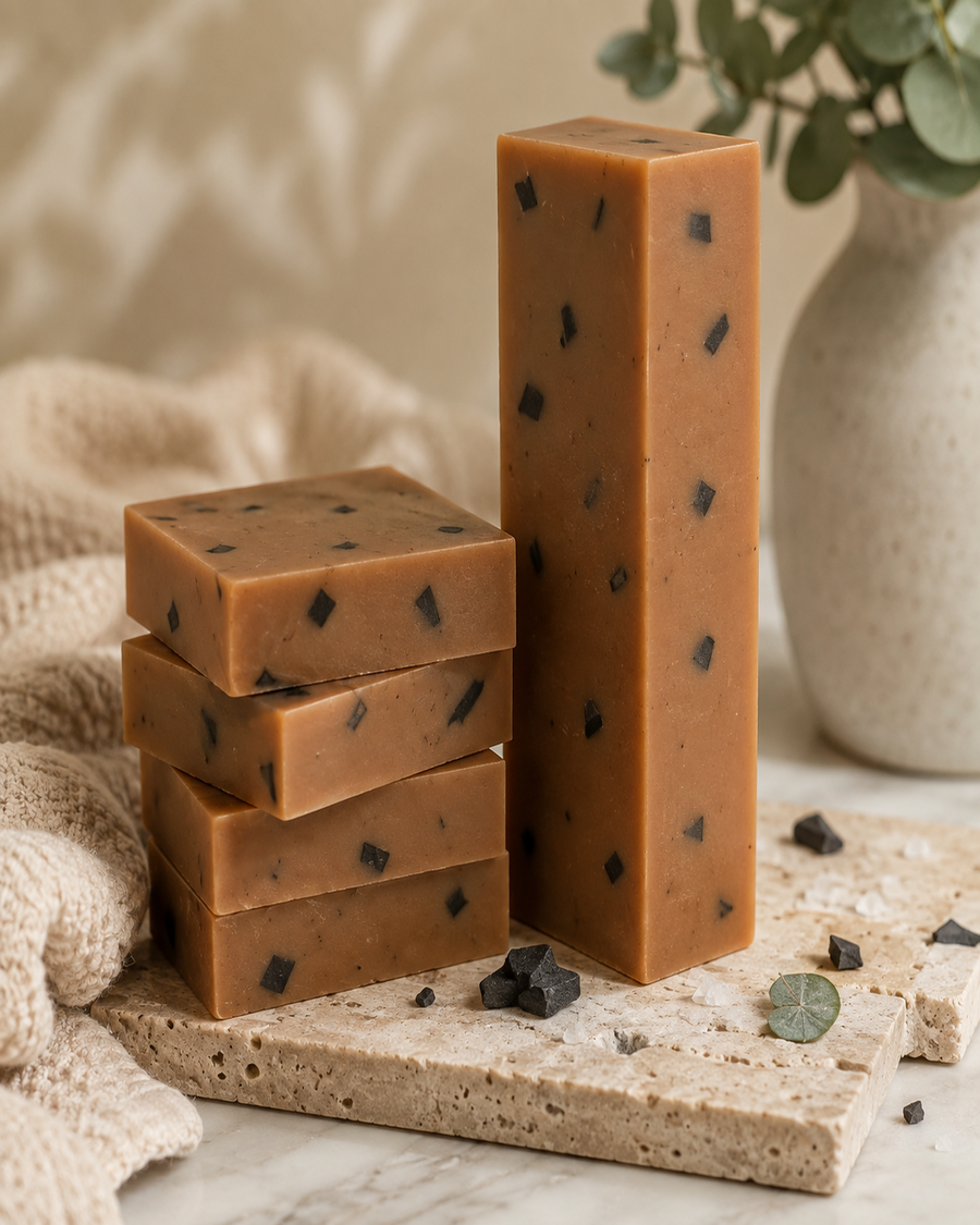 MNRL Dead Sea Mud Scrub Soap bars, tan-amber base with activated charcoal flecks